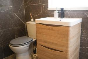 a bathroom with a white sink and a toilet at Eia Street Apartments Belfast in Belfast