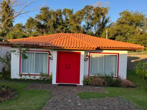 una pequeña casa con techo naranja y puerta roja en Alma Iguassu, en Foz do Iguaçu