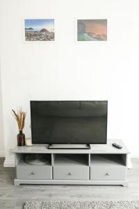 a white entertainment center with a flat screen tv on top at Eia Street Apartments Belfast in Belfast