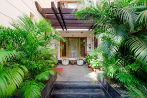 a courtyard with palm trees in front of a house at Ahuja Residency Cyber City I in Gurgaon
