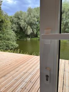 una puerta a una terraza con vistas al lago en Quinze suites et wellness de luxe en Ciney