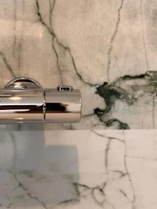 um close-up de uma escova de dentes de prata em um balcão de mármore em Quinze suites et wellness de luxe em Ciney