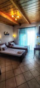 a bedroom with two beds and a large window at Αλκυονη Διαμερισματα in Paralia Vrachou