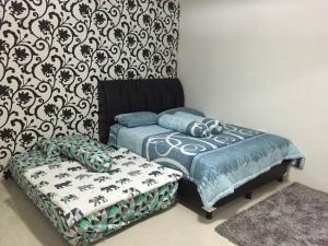 una camera con due letti, un divano e un muro di Rumah di sewa di sentul city a Karangtengah