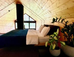 sypialnia z łóżkiem w pokoju z roślinami w obiekcie Leśny Azyl w mieście Kępiaste