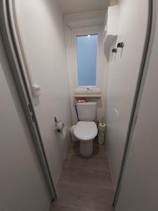uma pequena casa de banho com um WC e uma janela em Mobil home climatisé 6pers. 3CH camping domaine de chaussy 5* Ardèche em Lagorce