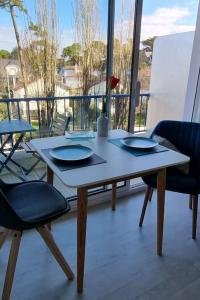 een tafel en stoelen in een kamer met een raam bij Océan bleu - Studio bord de plage in La Baule