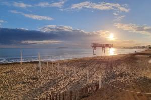 een uitzicht op een strand met zonsondergang bij Océan bleu - Studio bord de plage in La Baule