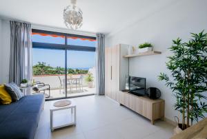 a living room with a blue couch and a large window at Cozy apartment with seaview and parking in Adeje