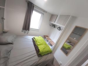 Mobil home climatisé 6pers. 3CH camping domaine de chaussy 5* Ardèche في لاغورس: غرفة نوم صغيرة مع سرير ومرآة