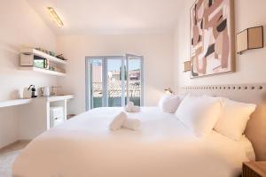 ein weißes Schlafzimmer mit einem großen Bett mit weißen Kissen in der Unterkunft Pick A Flat's Apartments in Saint-Tropez - Rue des Bouchonniers in Saint-Tropez
