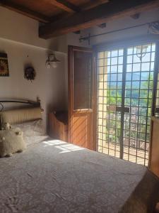 a bedroom with a large bed and a large window at La Maggiorana in Tagliacozzo