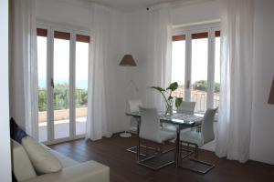 a living room with a table with a laptop and chairs at Appartanvilla Magellano in Mondello