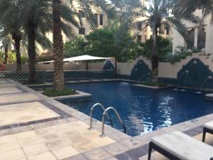 una piscina con palmeras en un hotel en Burj Dubai Area - 5min Walk - Luxury 2 Bedroom Apartment, en Dubái