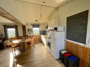 eine Küche mit einem Tisch und einem weißen Kühlschrank in der Unterkunft Slow Travel Mývatn - Óli's Homestay-Private house v in Mývatn