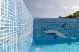 une fresque d'un requin sur le côté de la piscine dans l'établissement La Casa del Abuelo, à Zuheros