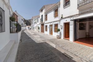 an empty street in a town with white buildings at La Casa del Abuelo in Zuheros