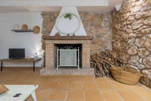 a living room with a stone fireplace with a mirror at La Casa del Abuelo in Zuheros