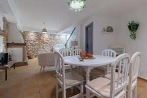 a dining room with a white table and chairs at La Casa del Abuelo in Zuheros