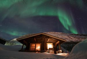 a cabin with the aurora in the sky at Villa Pikku Saana in Kilpisjärvi