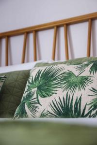 un cuscino con palme su un letto di Downtown Charming Apartments Apartamento Ponte a Chaves