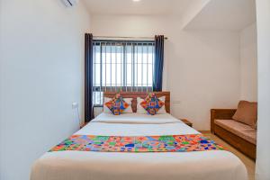 a bedroom with a large bed and a couch at FabHotel The Address in Nashik