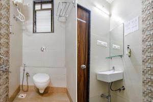 a bathroom with a toilet and a sink at FabHotel The Address in Nashik