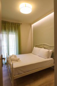 1 dormitorio con 1 cama y ventana grande en East & West Seaside Apartments, en Gialtra