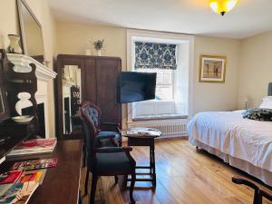 a bedroom with a bed and a desk and a tv at Porters Coffee Shop and B&B in Helmsley