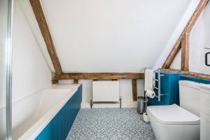 a bathroom with a toilet and a bath tub at The Hayloft Valley Farm Barns, Snape in Saxmundham +16 photos