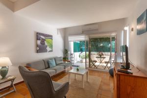 a living room with a couch and a table at BeGuest Gandarinha Apartment in Cascais