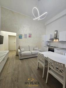 a white living room with a couch and a table at My Place Apartments in Policoro