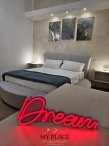 een slaapkamer met twee bedden en een rood bord dat leest droom mijn plaats bij My Place Apartments in Policoro