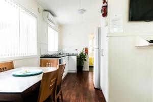 a kitchen with a table and a refrigerator at The Retreat Port Stephens in Anna Bay