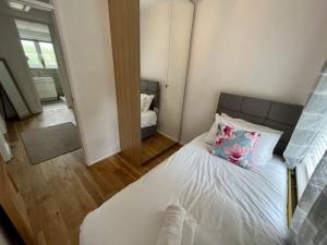 a bedroom with a white bed with a flower pillow at Spacious Family home in Cardiff with Parking! in Cardiff