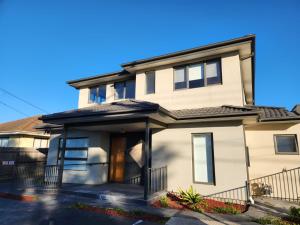 a white house with a black roof at Maruve Guesthouse 12 min from Melb airport in Melbourne