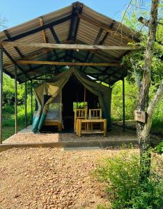 Zelt mit einem Bett und einem Tisch in der Unterkunft Murchison Giraffe Camp in Murchison Falls National Park