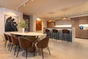 Anfitrión Villas & Suites في مربلة: غرفة طعام مع طاولة وكراسي