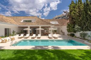 een zwembad in de achtertuin van een huis bij Anfitrión Villas & Suites in Marbella
