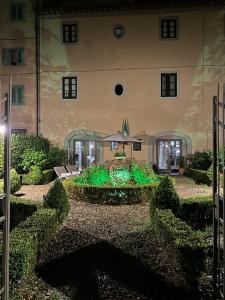 un grand bâtiment avec un jardin en face dans l'établissement BORGO DI BEPPE E GLORIA SUITE, à San Giovanni Valdarno