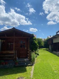 a small cabin with a grass yard in front of it at Grandma’s Cottage in Săcele