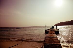 two people standing on a pier over the water at Tuna Bay Island Resort in Perhentian Islands