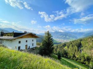 ein Haus auf einem Hügel mit Blick auf ein Tal in der Unterkunft Schallerhof Sterzing - Deine Auszeit mit Ausblick in unseren Ferienwohnungen auf dem Bauernhof in Südtirol in Gossensaß