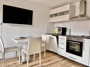 バンベルクにあるShining apartment in Bambergの白いキャビネット、テーブルと椅子付きのキッチンが備わります。