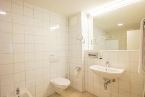 a white bathroom with a toilet and a sink at flexymotel Spielberg in Spielberg