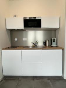 a white kitchen with a sink and a microwave at Vivez le panorama à 180 - PARKING - Proximité de la gare in Le Havre