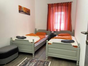 two twin beds in a room with a window at Apartman Kraljica 2 in Kupres