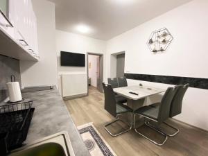a dining room with a white table and chairs at Apartman Kraljica 2 in Kupres