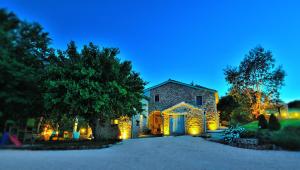 an old stone house with lights on a driveway at Antico Borgo in Arcevia