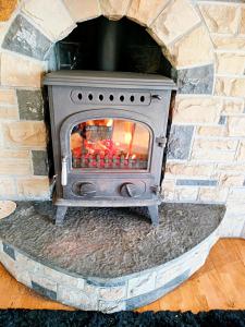 estufa de piedra en una chimenea de ladrillo en Tour House, A Country Escape set in Natures Beauty, en Youghal